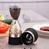Dual chamber pepper grinder with black and white peppercorns on a kitchen counter