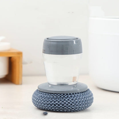Gray dish scrubber with soap dispenser on a kitchen counter