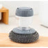 Kitchen soap dispensing scrubber with metal scouring pad on wooden surface