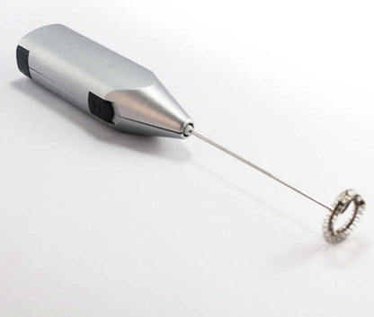 Stainless steel handheld milk frother for coffee and kitchen use on white background