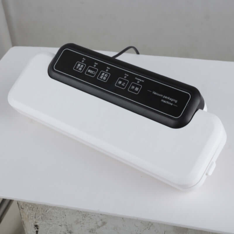 Electric vacuum sealer machine for food storage on white table
