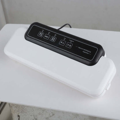 Electric vacuum sealer machine for food storage on white table