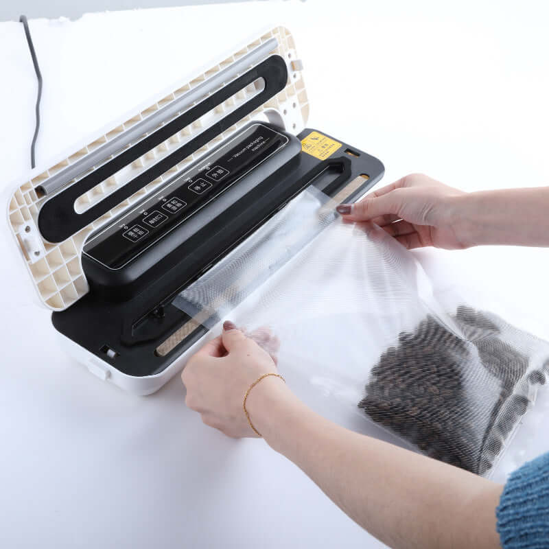 Hands sealing food in a vacuum sealer machine for kitchen food storage