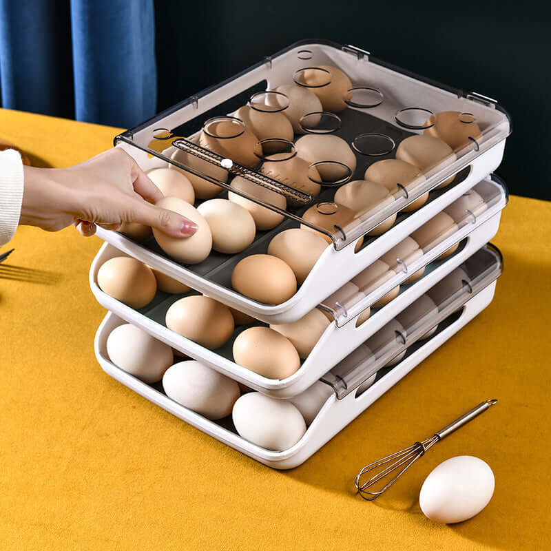 Stacked plastic egg storage containers with lids holding brown and white eggs on a kitchen table