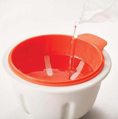 Red and white plastic mixing bowl with handle, being filled with water, kitchen accessory