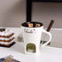 Ceramic chocolate fondue mug with tealight, melting chocolate, fondue fork, and dessert.