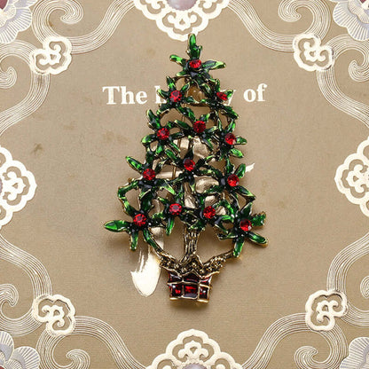 Festive Christmas tree brooch with green and red crystals on decorative background