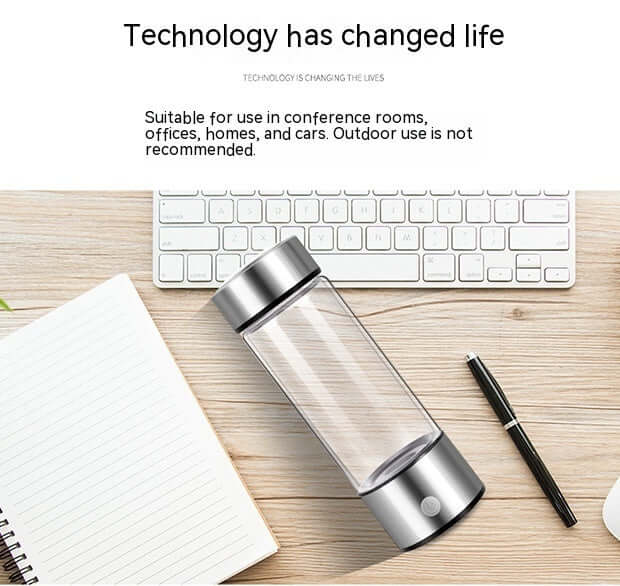 Electric portable blender bottle on office desk with keyboard, notebook, and pen