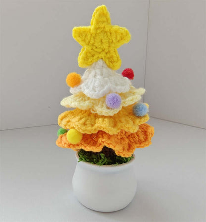 Crocheted Christmas tree decor with yellow star and pom poms in a small white pot