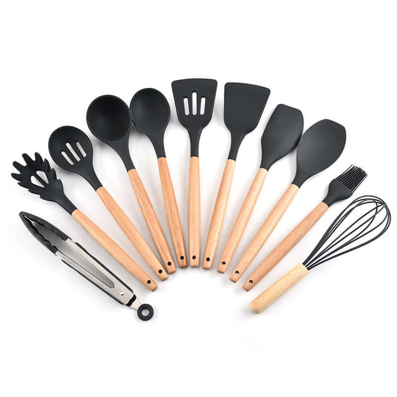 Set of black silicone kitchen utensils with wooden handles, including spatulas, spoons, whisk, and tongs, on white background.