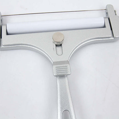 Metal cheese slicer with adjustable wire and white roller on a light surface