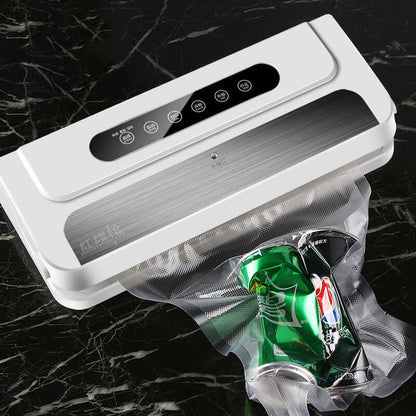 Automatic vacuum sealer machine sealing soda cans, kitchen appliance on black marble counter