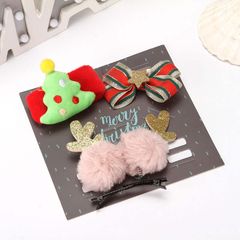 Set of festive Christmas hair clips with tree, bow, and reindeer designs on display card