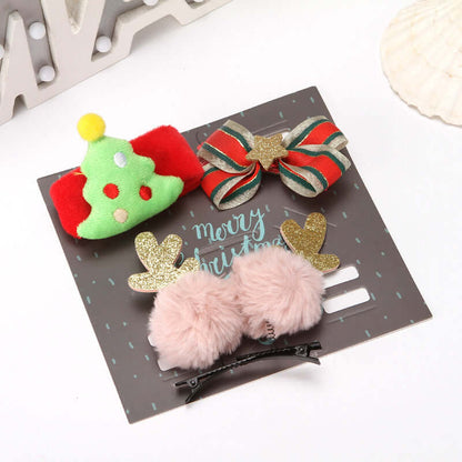Set of festive Christmas hair clips with tree, bow, and reindeer designs on display card