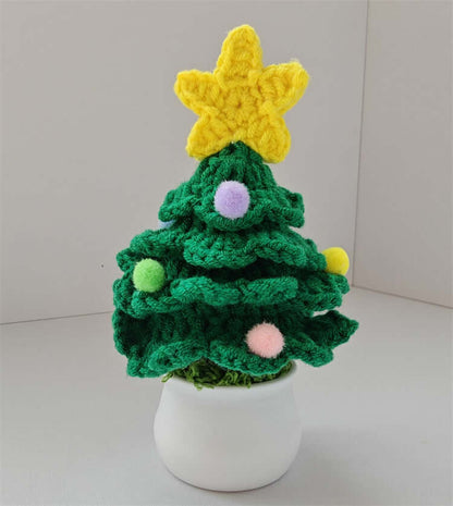 Crochet Christmas tree with colorful pom poms and yellow star in a white pot