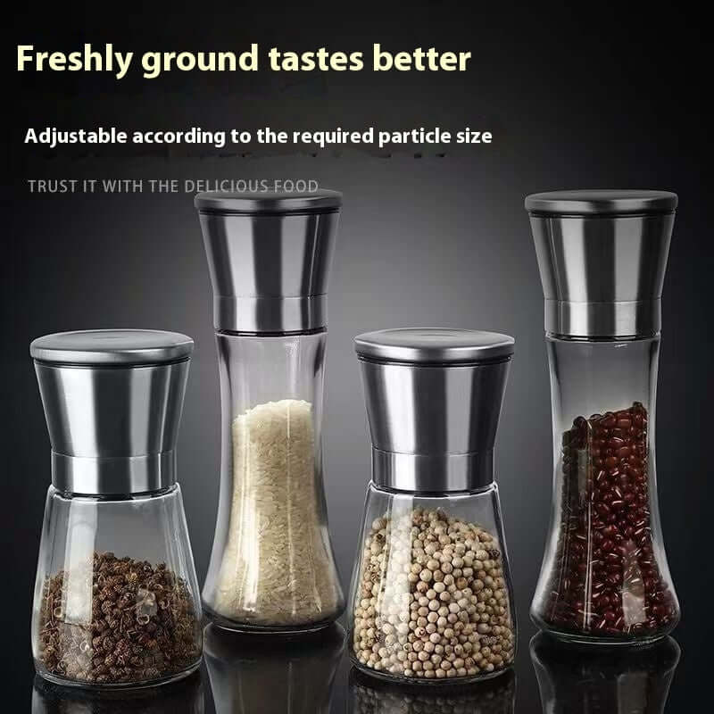 Set of stainless steel and glass spice grinders for kitchen, filled with various spices.