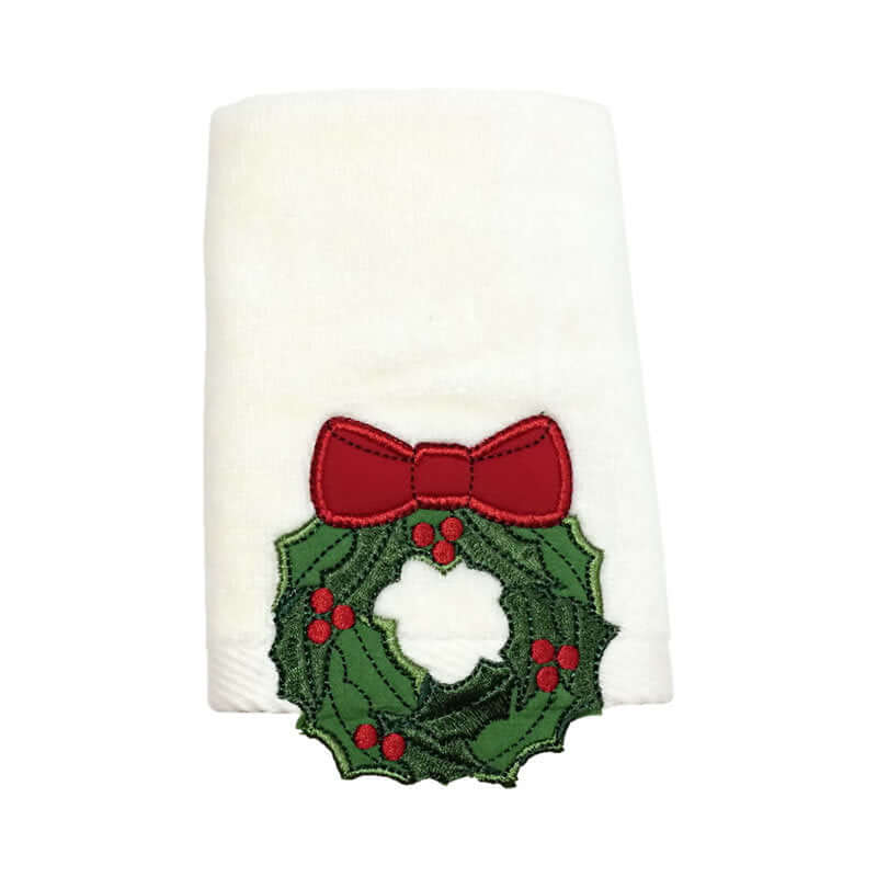 White kitchen towel with embroidered Christmas wreath and red bow