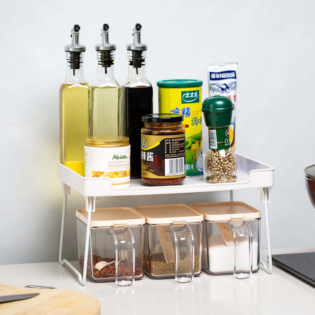 Kitchen spice organizer rack holding oil bottles, spices, and seasoning containers on countertop