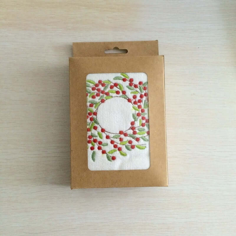 Kitchen dishcloth with red berry wreath design in eco-friendly cardboard packaging