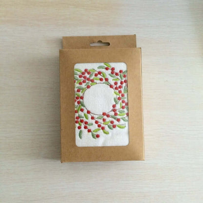 Kitchen dishcloth with red berry wreath design in eco-friendly cardboard packaging