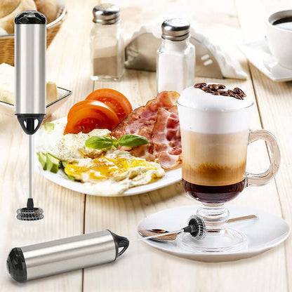 Stainless steel milk frother with cappuccino, breakfast plate, and kitchen accessories.