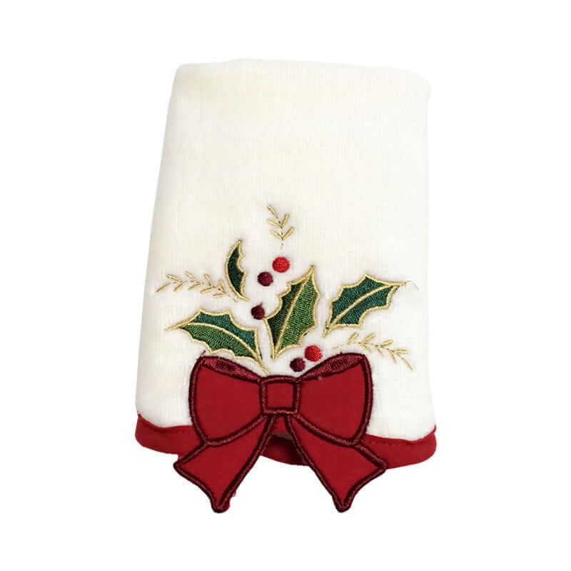 White kitchen towel with embroidered holly leaves, red berries, and a festive red bow