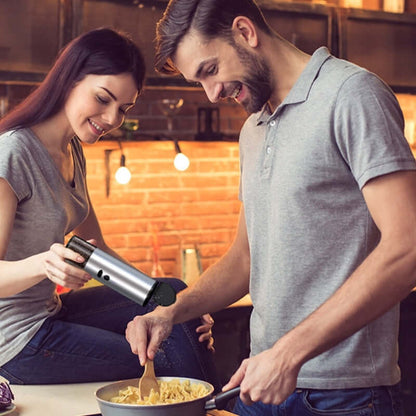 Couple using stainless steel kitchen gadget to season food while cooking pasta