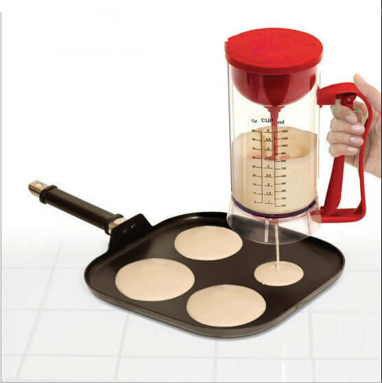 Pancake batter dispenser pouring onto square non-stick griddle with pancake molds