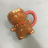 Ceramic gingerbread man mug with red handle, cute kitchen accessory on gray background