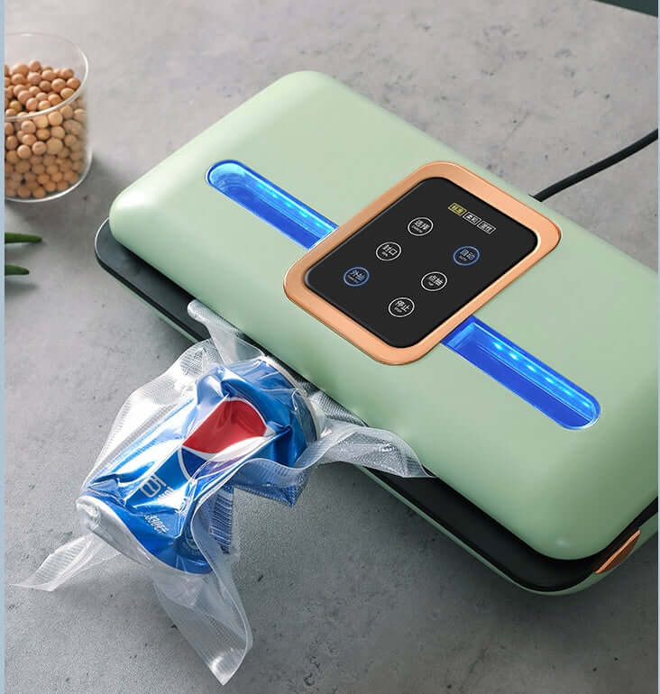 Green vacuum sealer machine sealing plastic bag on kitchen counter