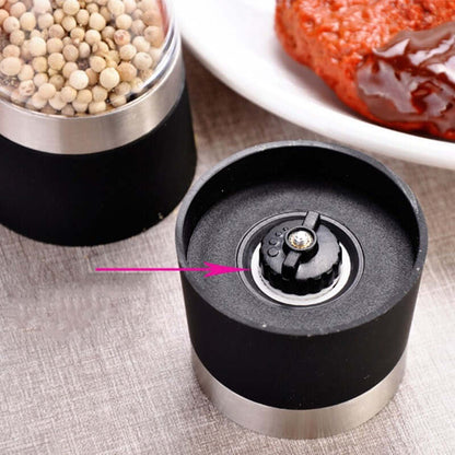 Adjustable pepper grinder mill with close-up of grinding mechanism and peppercorns