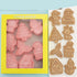 Christmas themed cookie mold set with pink plastic cutters and festive shaped cookies