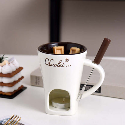Ceramic chocolate fondue mug set with tealight, dipping fork, and wafers on table