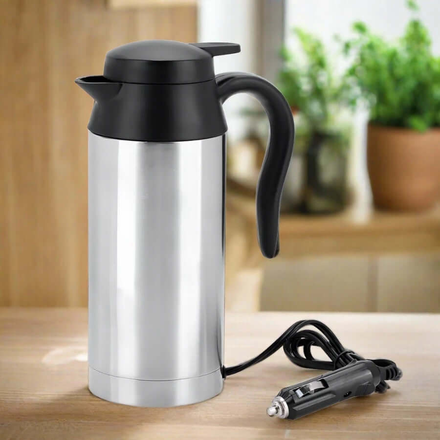Stainless steel electric travel kettle with car adapter on a kitchen counter