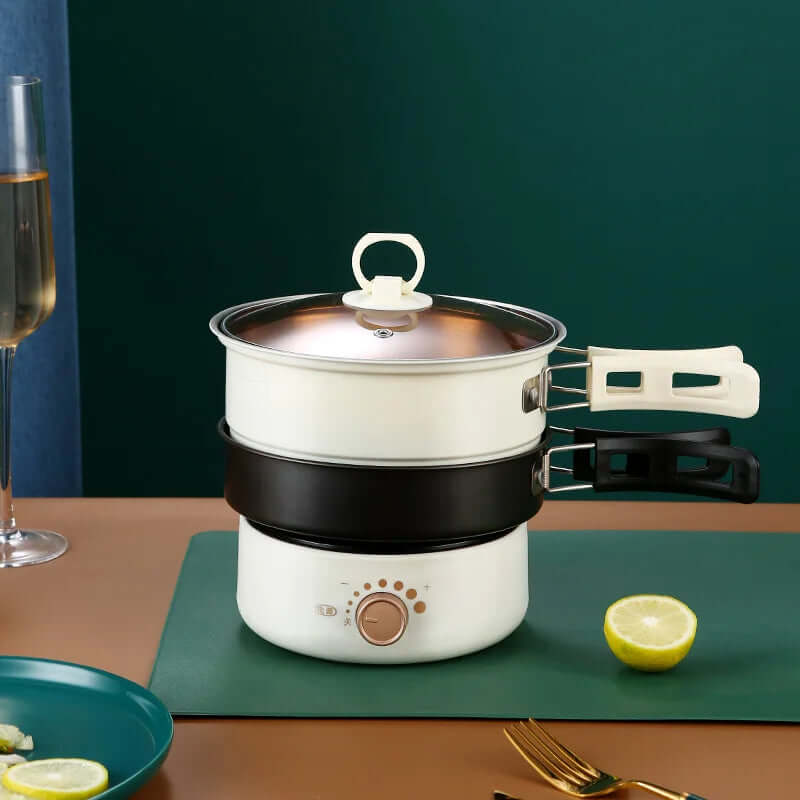Multi-layer electric hot pot with steaming tray on kitchen table, kitchen appliance