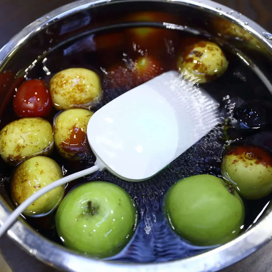 Fruit cleaner device in water with apples and tomatoes in a stainless steel bowl