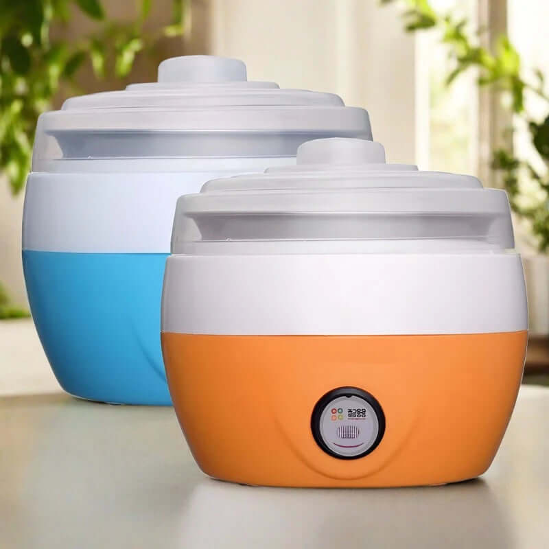Two colorful electric yogurt makers with lids on a kitchen counter, modern kitchen appliance.