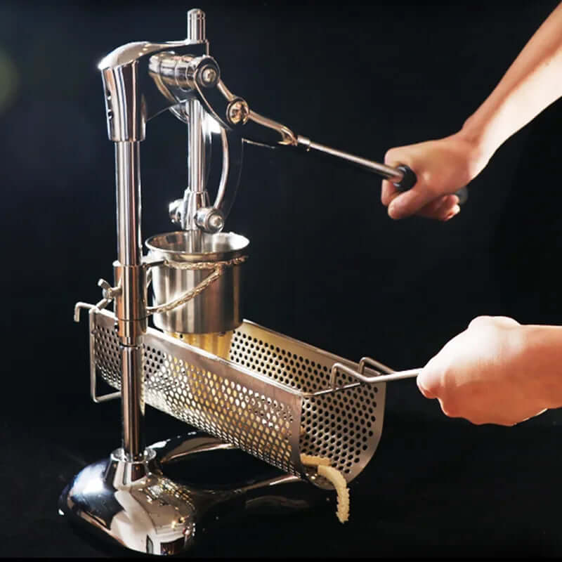Manual stainless steel potato ricer press with perforated basket in use on black background
