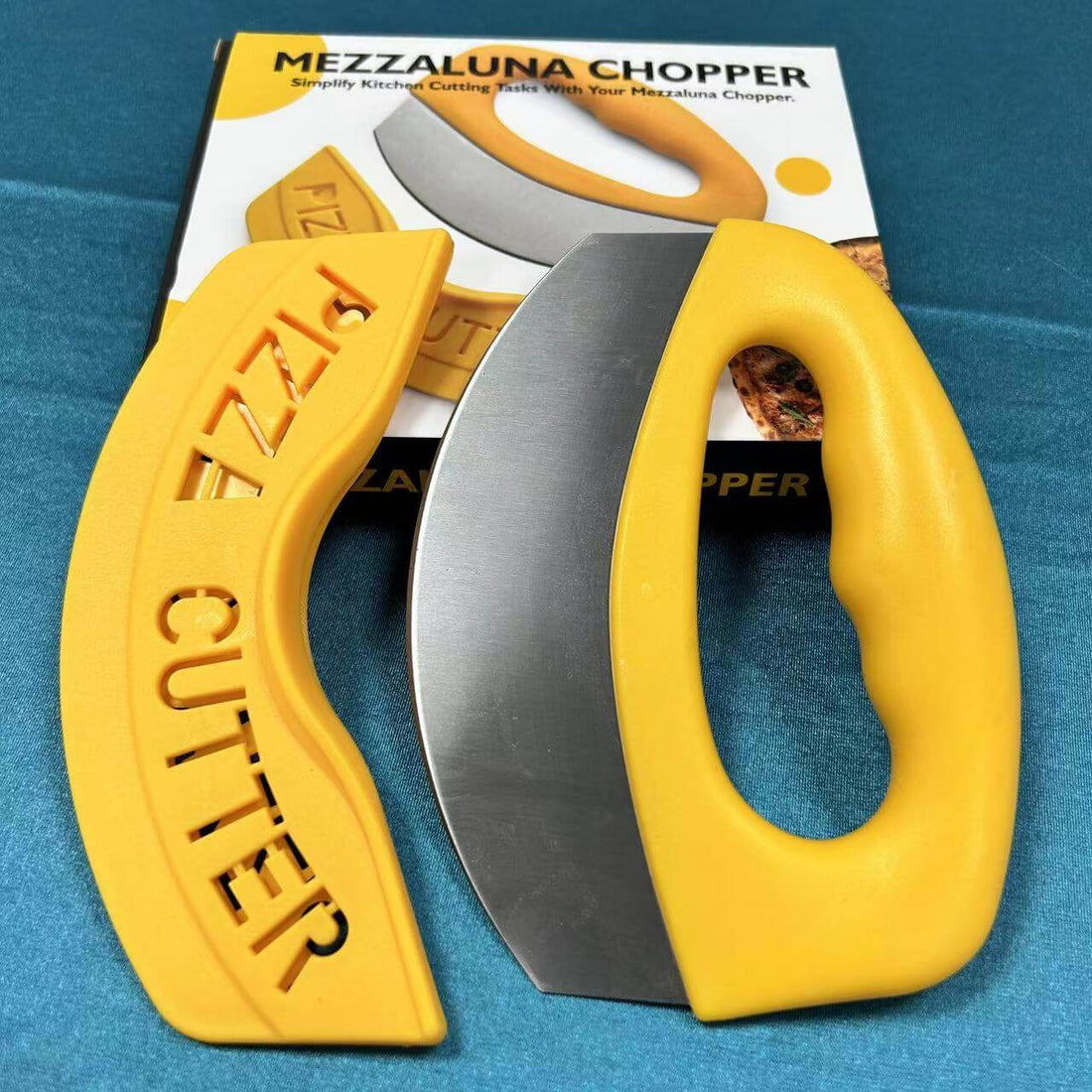 Yellow mezzaluna chopper pizza cutter with protective cover on blue surface