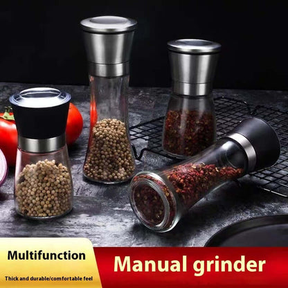 Set of glass and stainless steel manual spice grinders for kitchen, filled with peppercorns.