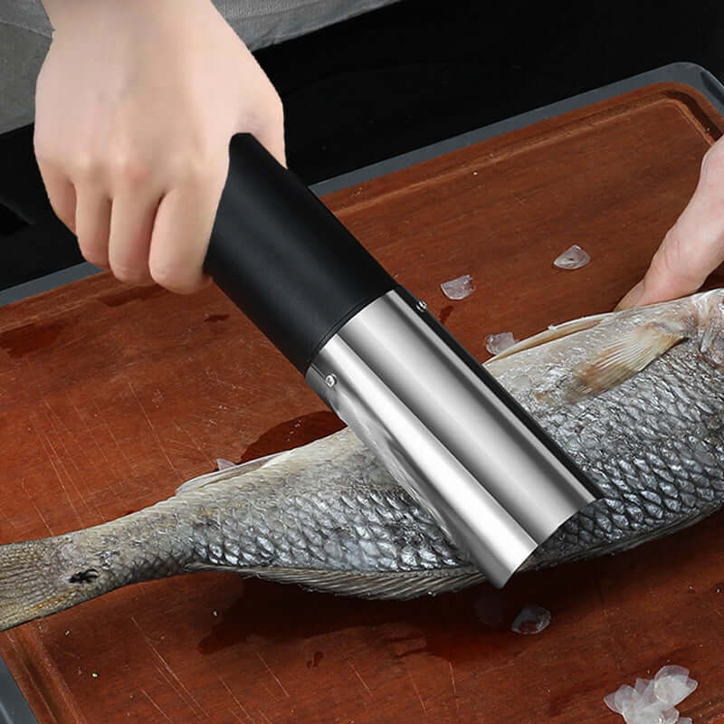 Stainless steel fish scaler tool removing scales from fresh fish on cutting board