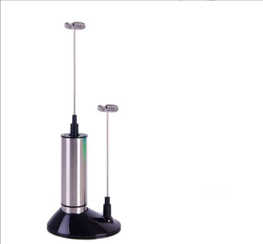 Stainless steel electric milk frother with detachable whisk heads on a stand.
