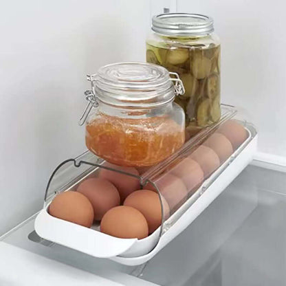 Refrigerator egg container with brown eggs, glass jars of pickles and jam on top