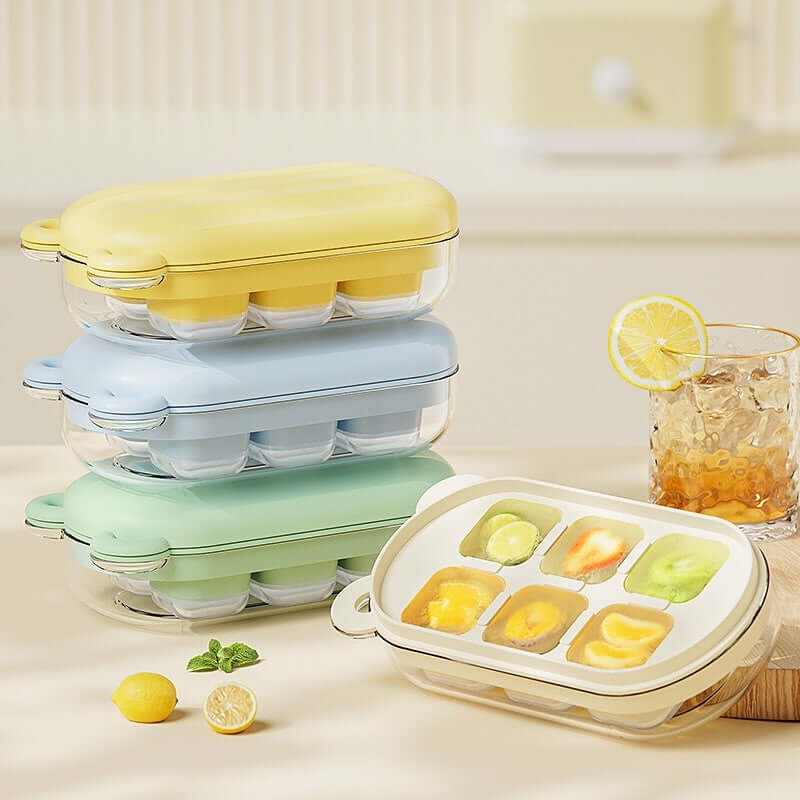 Stacked pastel ice cube trays and one open tray with fruit-filled cubes on kitchen counter
