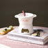 Ceramic chocolate fondue pot with fork and tealight on books, elegant kitchen accessory display
