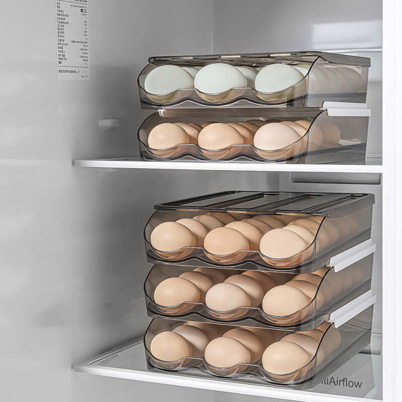 Stacked clear plastic egg storage containers filled with eggs in a refrigerator.
