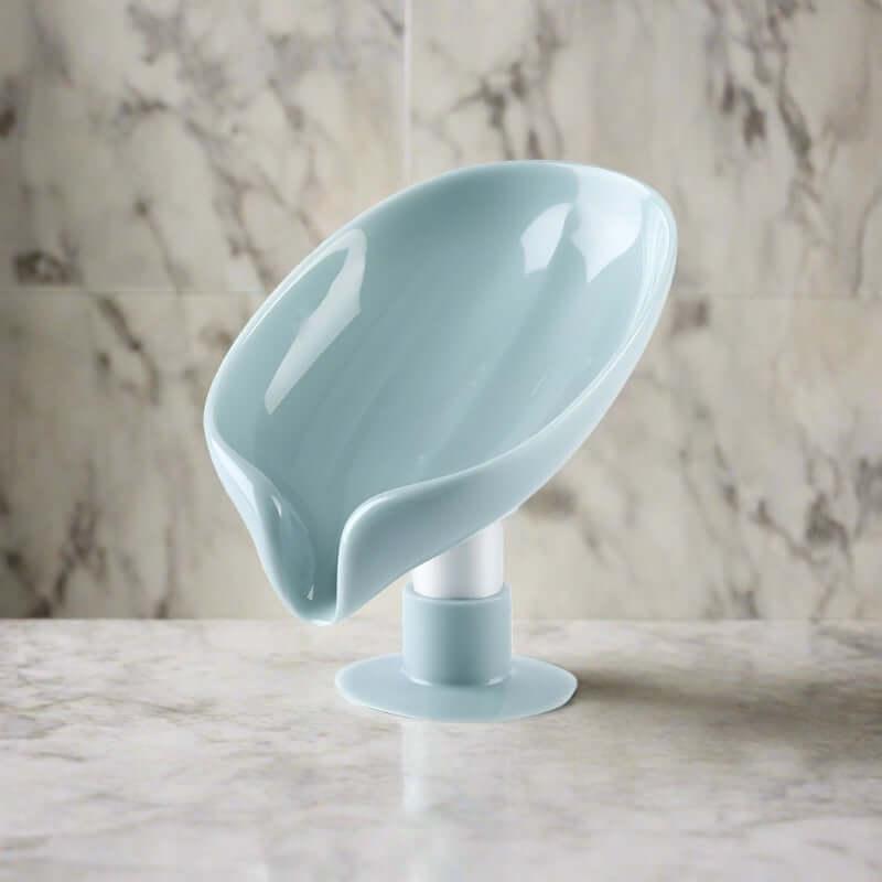 Light blue plastic spoon rest with stand on marble kitchen countertop