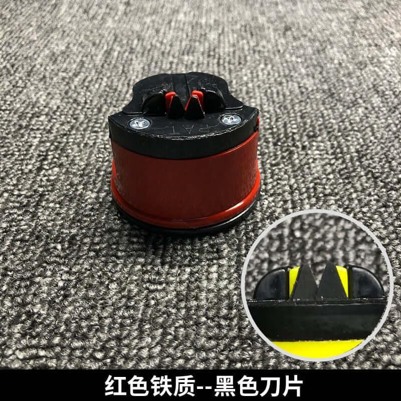 Red and black kitchen knife sharpener with suction base on textured surface, close-up of sharpening blades inset.